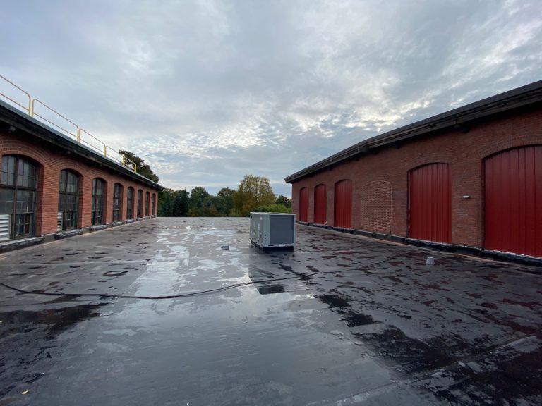 Finished rubber roof replacement between brick buildings in Boston